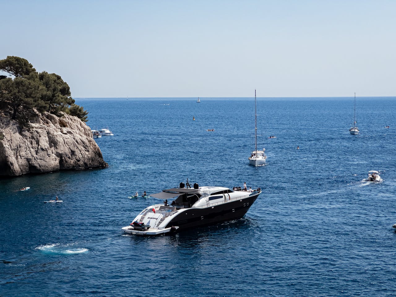 Crafting Captivating Headlines: Your awesome post title goes here 1 A luxury yacht cruising the Mediterranean Sea with scenic cliffs and sailboats on a sunny day.